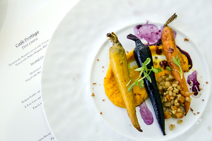 Plate of carrots in a sauce with a menu under the plate