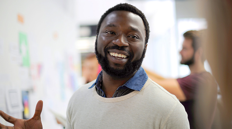 Man smiling wearing a woven sweater