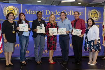 Group of faculty members receiving awards stand together at an awards ceremony