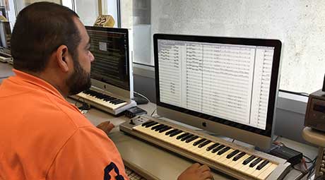 Staff member helps student at keyboard