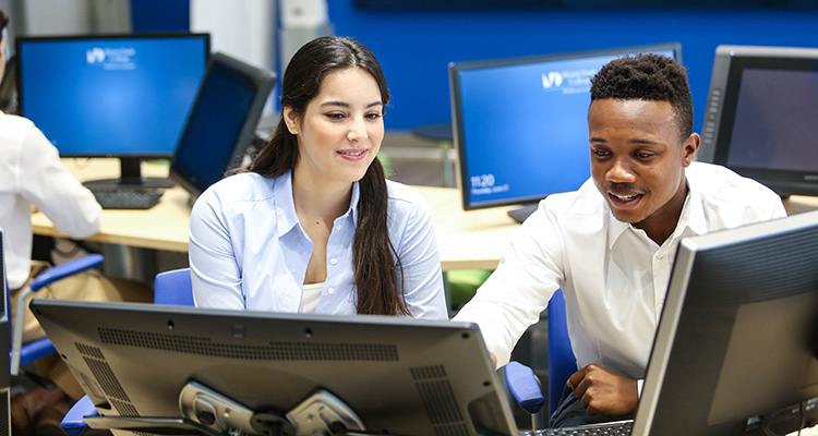 a female and male student working at a computer lab with a laptop