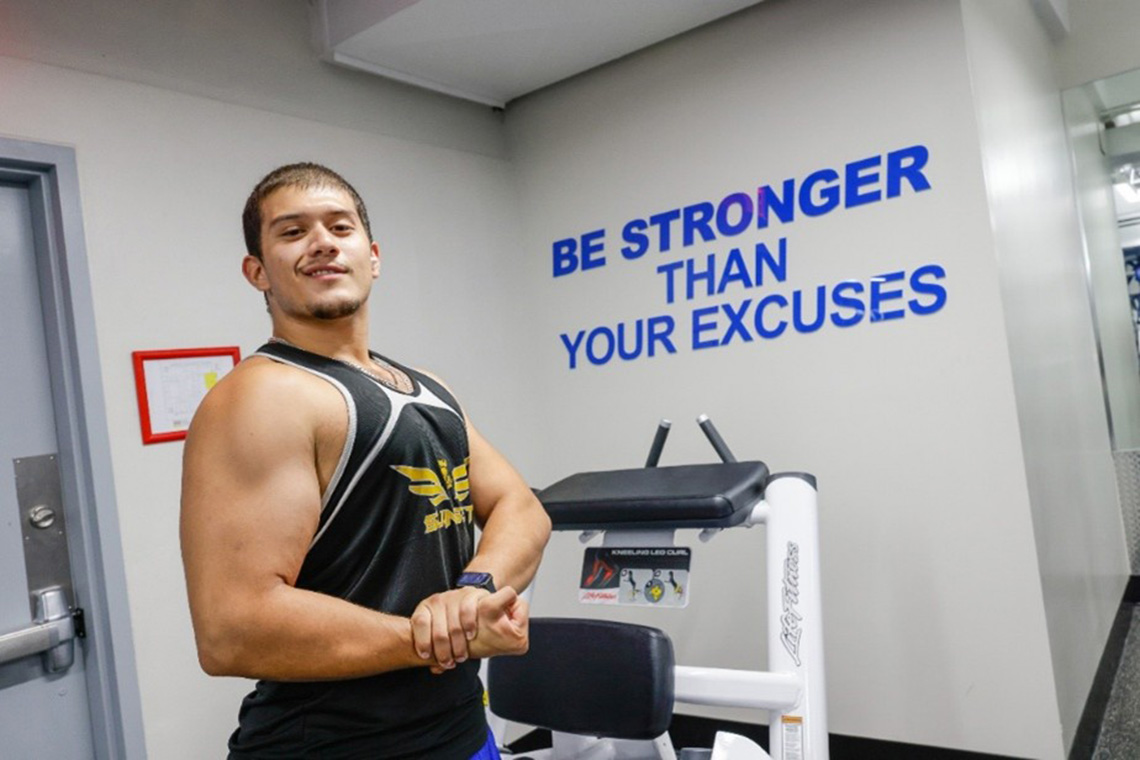 Gym member flexing his arm muscles