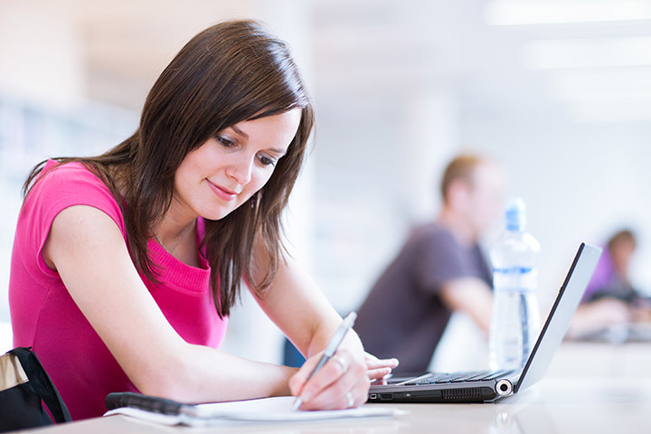 girl in bright pink shirt using laptop