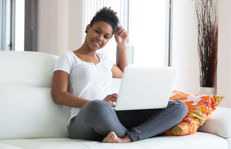 Woman sitting on couch with laptop